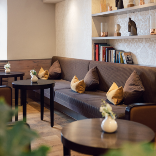 14 Gemütliche Lounge im Innsbruck Hotel mit modernem Interieur, braunen Sofas und stilvollen Dekorationen.
