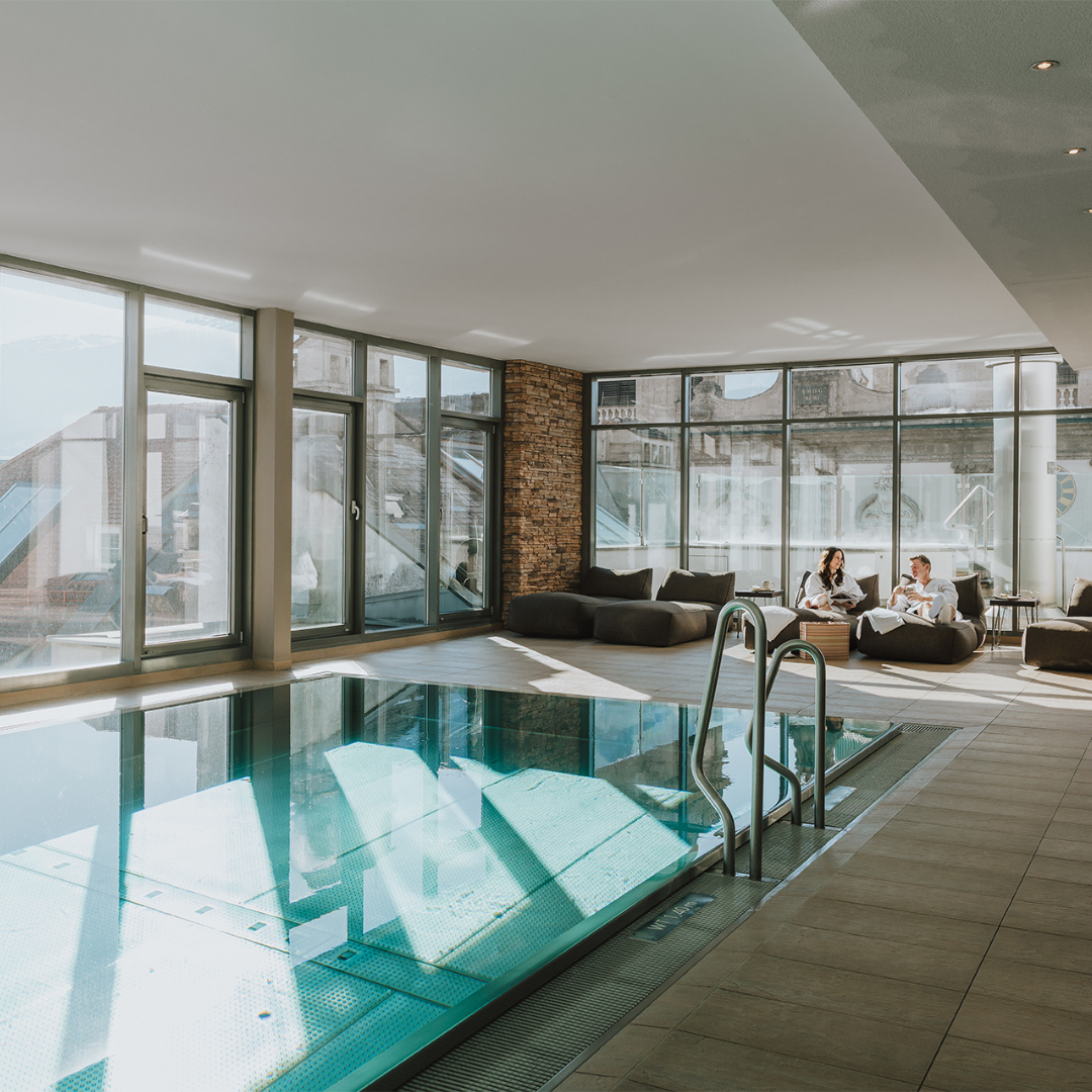 15 Innenpool im Innsbruck Hotel mit Panoramafenstern und gemütlichen Sitzgelegenheiten für ultimativen Komfort und Entspannung.